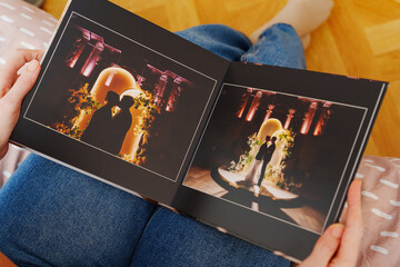 Female hands flipping through a photo book with wedding photos