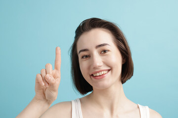 Woman with contact lens on light blue background