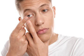 Man putting in contact lens on white background, closeup