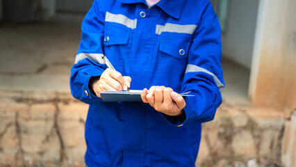A construction foreman is checking on building quality checklist report during inspecting at the...