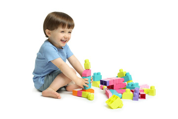 Cute little boy playing with building bricks on white background