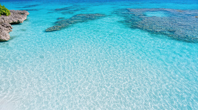 Crystal clear turquoise water gently laps against rocky shores, creating serene coastal scene