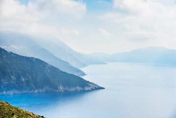 Beautiful landscape with the sea and rocky hill ranges in Greece against a cloudy sky.