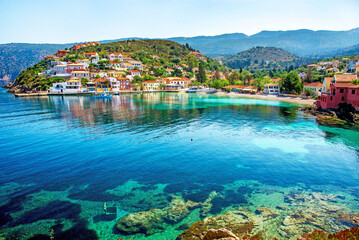 Beautiful landscape with bay and colorful buildings on the background of picturesque clouds in the town of Asos, Greece, Kefalonia. Wonderful exciting places.