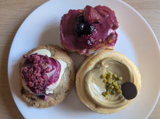 close up of desserts collection with cookie, cheesecake, raspberry, and cinnamon roll, sweet tasty treats.