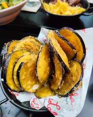 Close-up of fried sweet eggplant slices, a traditional Spanish tapas dish. Golden, crispy, and delicious appetizer or snack with rich flavor.

