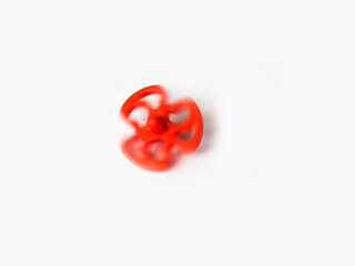 Beautiful and cute red color plastic spin toy isolated on white background.