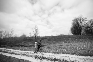 Cycling adventure through a serene landscape with a parent and child enjoying a quiet ride on a...