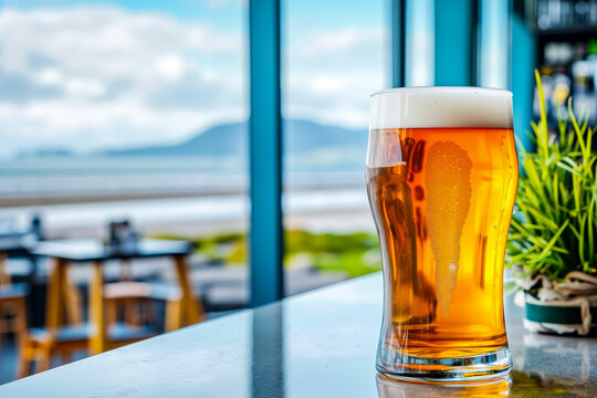 Fototapeta A glass of beer sitting on top of a table