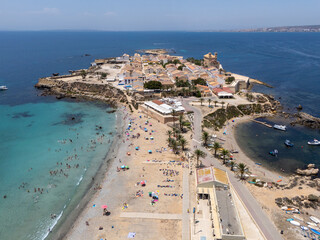 Aerial view of a scenic Mediterranean beach with turquoise waters, sandy shore, and coastal village...