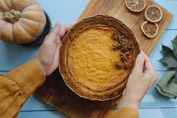 Pumpkin pie garnished with anise. Woman made homemade pumpkin pie for Thanksgiving