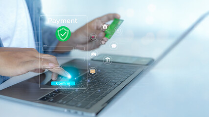 A person confirming an online payment using a credit card on a laptop.