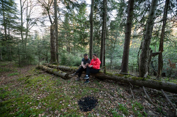 Couple enjoys peaceful moment together in serene forest setting during late afternoon with vibrant...