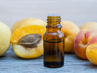 A bottle of apricot kernel oil with fresh ripe fruit
