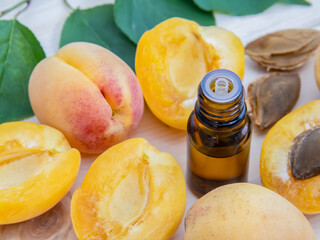 A bottle of apricot kernel oil with fresh ripe fruit