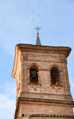 Bell tower of Santa Maria Del Salvador church under blue sky in The old town of Chinchilla de...