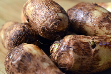 Group Of Taro Root Vegetable On Wooden Table Close Up