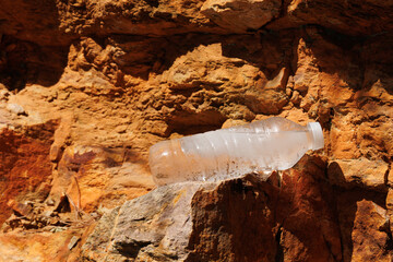 water bottle ice in it on the brown rocks