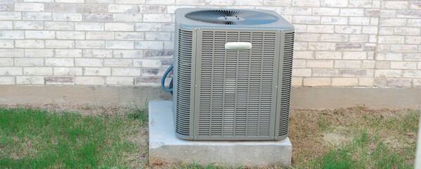 Panorama view outdoor HVAC unit and wall mounted electrical boxes installed along modern brick...