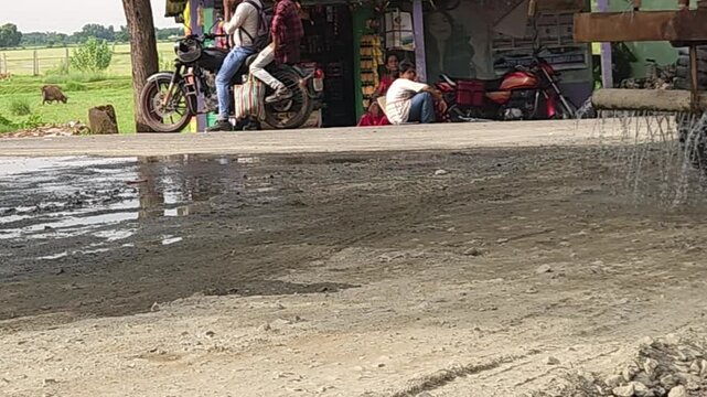 During the road construction works, a truck fitted watering machine sprinkles water over the new fresh asphalt pavement to reduce dust, repair and maintenance in the transportation industry.