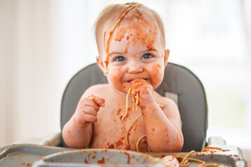 Little baby eating her dinner and making a mess
