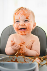 Little baby eating her dinner and making a mess