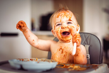 Little baby eating her dinner and making a mess