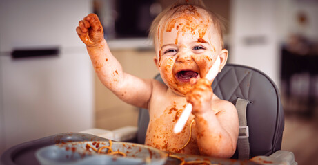 Little baby eating her dinner and making a mess