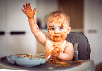 Little baby eating her dinner and making a mess