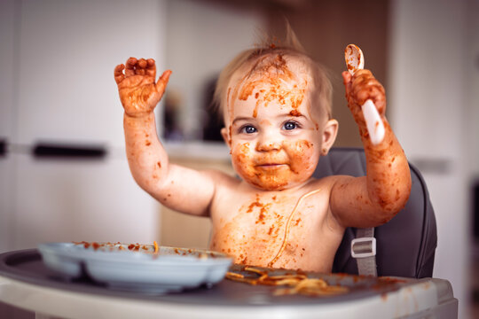 Little baby eating her dinner and making a mess