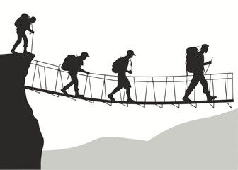 Silhouette of Hikers Crossing a Rope Bridge in the Mountains Teamwork Concept