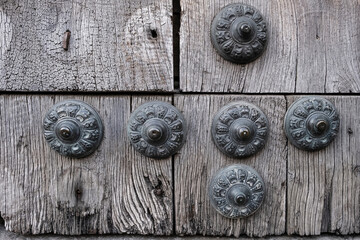Old wooden door with lock. Vintage decorative nails with ornament on an old wooden door.