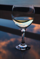 Glass of wine or water with reflection from sunset.shallow depth of field