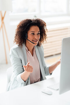 Mature customer service representative talking through headset in office