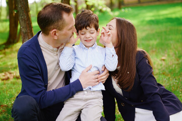 happy family moment with parents and child enjoying playful interaction in green park. loving...