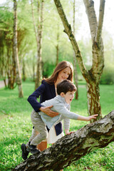 mother and child adventure in nature, enjoying playful outdoor activity on a sunny day in park...