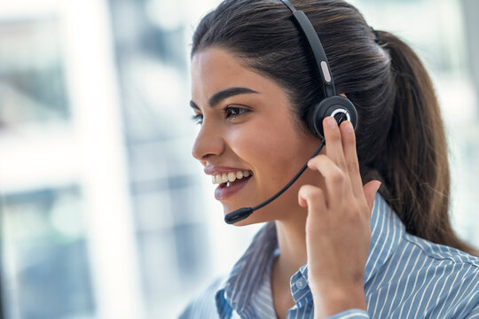 Smiling customer service representative using a headset in an office
