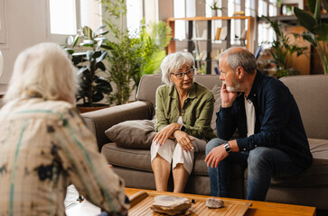 Senior couple discussing problems with psychologist at home