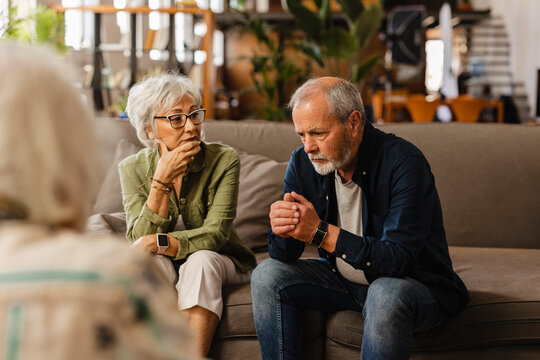 Senior couple worried and listening to therapist at home