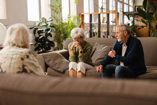 Senior woman suffering from depression is consoled by her friends at home
