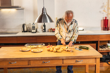 Senior man preparing vegetables in modern kitchen