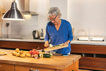 Senior woman preparing vegetables in modern kitchen