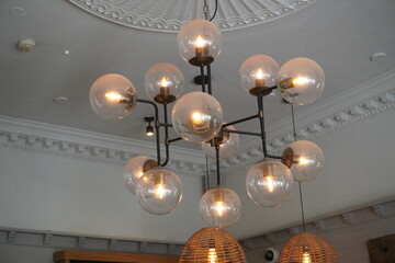 Lichfield, England - June 20 2025: Modern chandelier with classic elements illuminating a stylish...