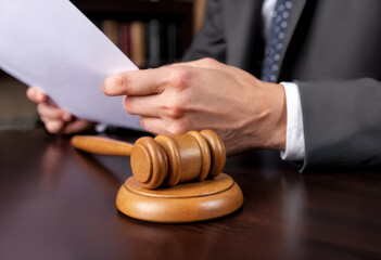 a lawyer works with documents and a wooden gavel in a courtroom or law enforcement office