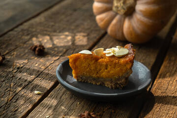 Delicious slice of pumpkin pie for Thanksgiving, adorned with sprinkle of almonds. 