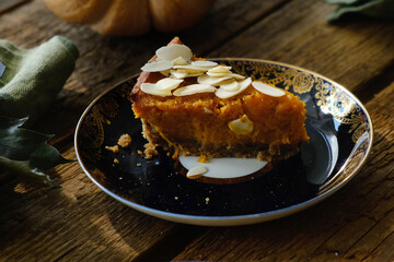Slice of pumpkin pie sprinkled with sliced almonds. Thanksgiving food.