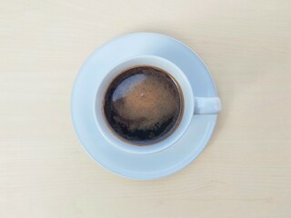 Black coffe in white glass on wooden table background, Top view 