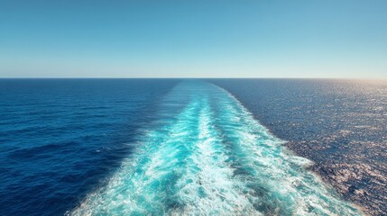 Ocean wake with white foamy waves trailing behind cruise ship on bright sunny summer day. Deep blue sea surface with water trail, splashing foam, and ripples in tropical seascape background