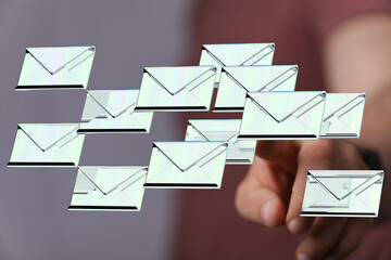 Hand interacting with digital emails, depicting inbox management challenges.