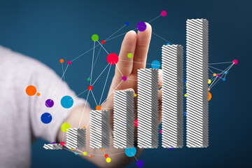 Hand interacting with a 3D bar chart, showcasing data analysis and business growth visualization.